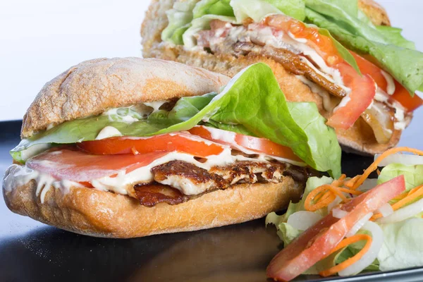 Close up de sanduíche BLT com salada em uma placa preta — Fotografia de Stock