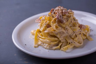 arka plan beyaz bir tabak makarna carbonara, yakın çekim