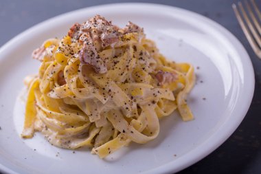 arka plan beyaz bir tabak makarna carbonara, yakın çekim
