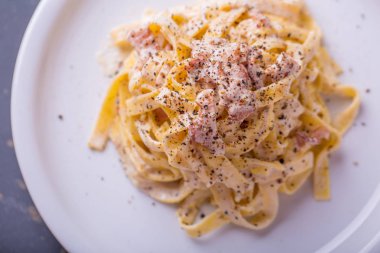 arka plan beyaz bir tabak makarna carbonara, yakın çekim