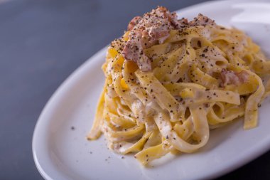 arka plan beyaz bir tabak makarna carbonara, yakın çekim
