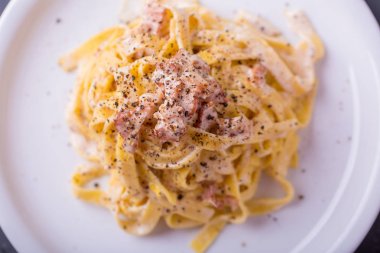 arka plan beyaz bir tabak makarna carbonara, yakın çekim