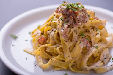 arka plan beyaz bir plaka üzerinde ev yapımı makarna carbonara, yakın çekim