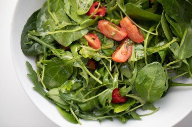 Lezzetli yeşil salatayı beyaz tabakta yakın. 