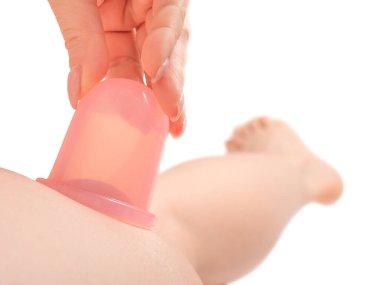 Kadın, vakum silikon kavanozu, uyluk masajı kullanarak beyaz arka planda anti-selülit masajı yapıyor.