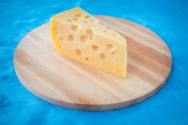 Pedazo Queso Con Agujeros Una Tabla Madera Pieza Queso Triangular — Foto de Stock