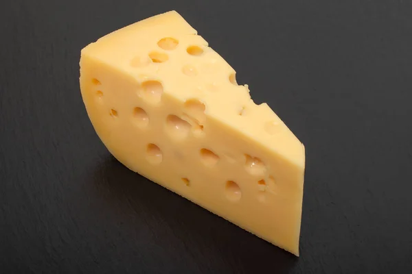 Brânză Galbenă Maasdam Brânză Triunghiulară Găuri Fundal Ardezie Neagră Piatră — Fotografie, imagine de stoc