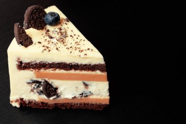 Koyu renkli bir arka planda çilek ve kurabiyelerle süslenmiş güzel bir pasta.