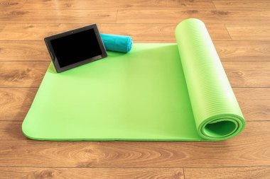 Evde yoga minderi, uzaktan yoga, yoga minderi, tablet ve havlu yoga ekipmanları. Sağlıklı yaşam tarzı, spor ve diyet kavramları.
