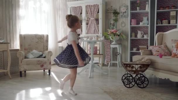 Küçük kız evde elbiseyle batan güneşin içinde iplik. ağır çekim — Stok video