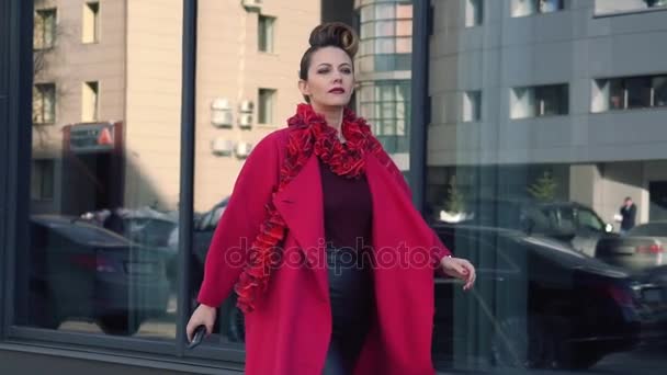 Confident woman with a beautiful unusual hairdress walks through the spring city. Girl on the background of modern architecture. SLOW MOTION — Stock Video