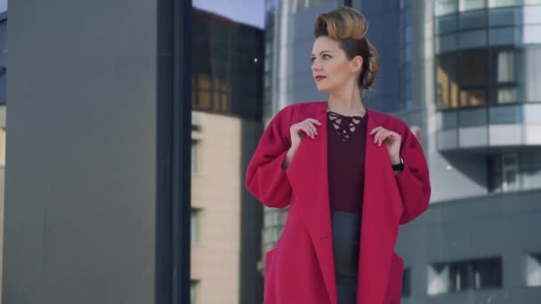 Mujer de confianza retrato con un hermoso peinado inusual pasea por la ciudad de primavera. Chica en el fondo de la arquitectura moderna. MOCIÓN LENTA — Vídeos de Stock