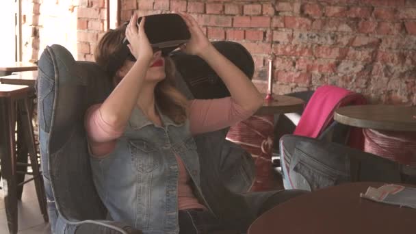 Женщина использует очки виртуальной реальности в кафе — стоковое видео