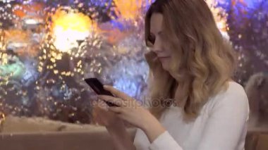 genç güzel kız cep telefonuyla bir arka plan üzerinde bir ileti gönderir