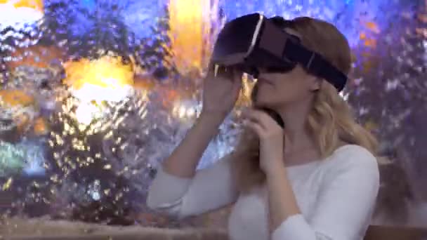 Mujer utiliza unas gafas de realidad virtual sobre fondo abstracto — Vídeos de Stock