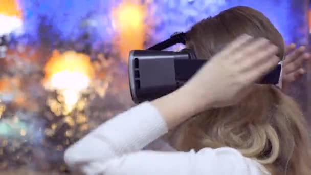 Vrouw zet op en maakt gebruik van virtual reality bril op een abstracte achtergrond — Stockvideo