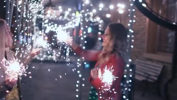 Girlfriends having fun together. girls dancing holding sparkling fireworks hands. slow motion — Stock Video