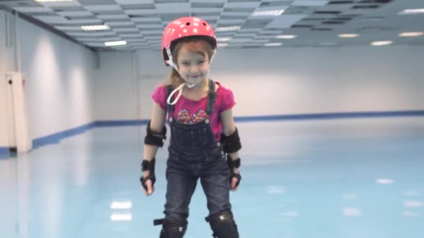 Little girl learns to skate. Child in helmet — Stock Video