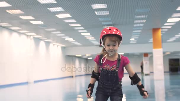 Criança em patins. Menina aprende a patinar no capacete — Vídeo de Stock