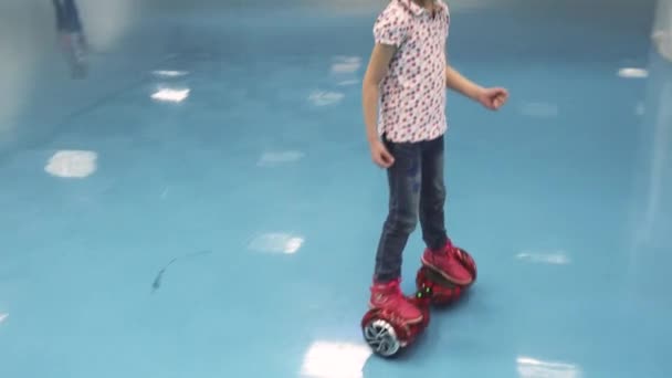 La niña está montando un hiroscooter. niño aprende a montar en segway — Vídeo de stock