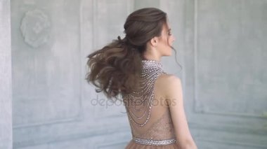 Festival makyaj ve kameraya poz ve gülümseyen saç modeli ile gece elbisesi içindeki genç çekici genç kız