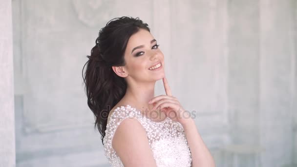 Atraktivní a roztomilá dívka pózuje na kameře ve večerních šatech. Slavnostní účes a make-up — Stock video