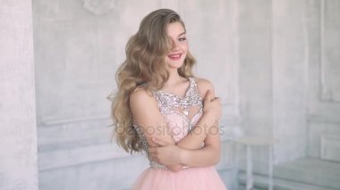 Neşeli genç kız kameraya poz. Akşam makyaj ve saç modeli akşam elbiseli kadın ile