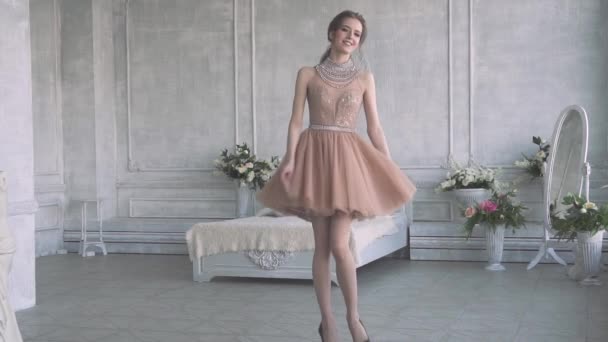 Menina bonito e atraente em um vestido de cocktail e divirta-se girando — Vídeo de Stock