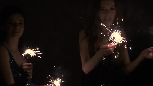 Meninas glamorosas e sexy dançando em uma festa com sparklers nas mãos — Vídeo de Stock