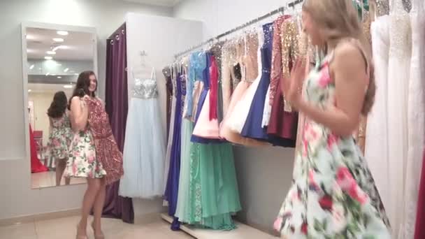 Ein junges charmantes Mädchen probiert in der Umkleidekabine ein Kleid an und wartet auf die Zustimmung ihrer Freunde — Stockvideo