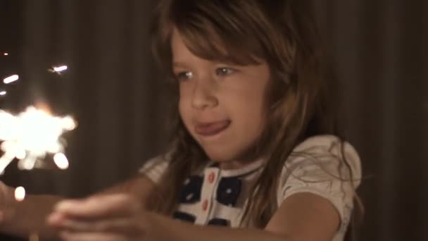 Kleines Mädchen im Urlaub ist glücklich und lächelt mit Wunderkerzen in den Händen — Stockvideo