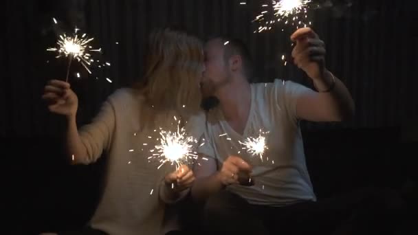 Lovers boy and girl with sparklers in hands having fun and kissing. slow motion — Stock Video
