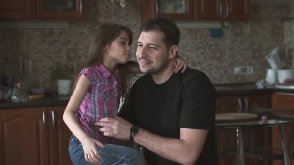 Маленька дівчинка цілує і обіймає свого батька. Батько і донька. повільний рух — стокове відео