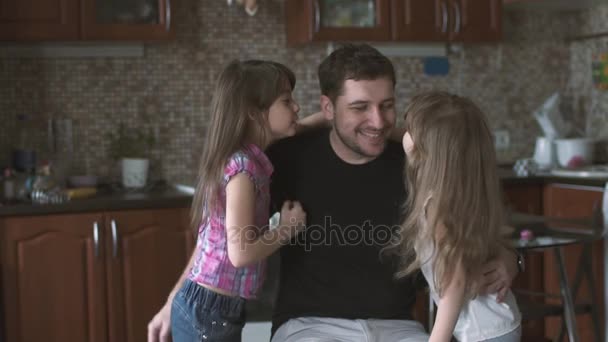 Twee kleine dochters oplopen tot hun papa geef hem knuffels en kusjes. Alleenstaande vader met zijn kinderen. Slow motion — Stockvideo