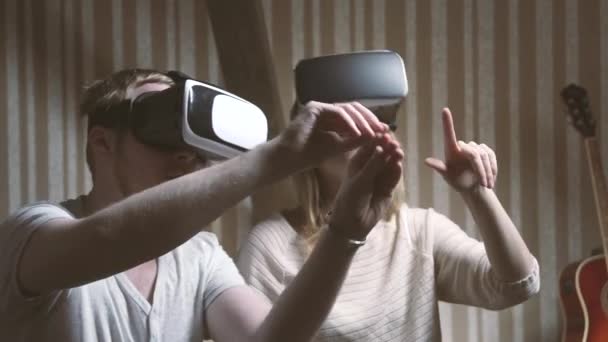 Junges Mädchen und ihr Freund blicken in Virtual-Reality-Brille durch Fotos — Stockvideo