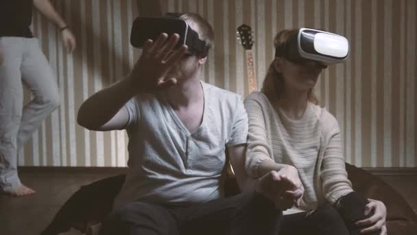 Młody człowiek przestraszony jego przyjaciół, które są odtwarzane przez okulary wirtualnej rzeczywistości — Wideo stockowe