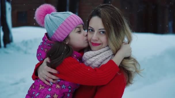 Hija besa a su madre tierna y cariñosamente. Mamá pasa tiempo con su bebé al aire libre. cámara lenta — Vídeos de Stock