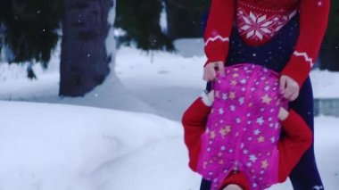 açık hava oyunları. Anne kızıyla kış ormandaki birlikte vakit geçiriyor. Anne ve çocuk yürüyor. ağır çekim