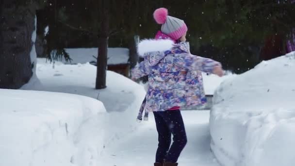 Criança ao ar livre. Menina está brincando e se divertindo ao ar livre no inverno no parque. câmara lenta — Vídeo de Stock