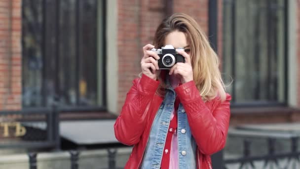 Turista toma fotos de las vistas en una cámara de cine. joven hermosa mujer sonriendo y tomando fotos — Vídeos de Stock