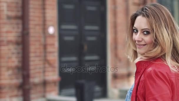 Primo piano ritratto di bella giovane donna bionda. Ragazze indietro. modello è da fotocamera, giri e sorrisi — Video Stock