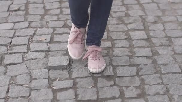 Дівчата ноги в кросівках, що йдуть на тротуарі — стокове відео