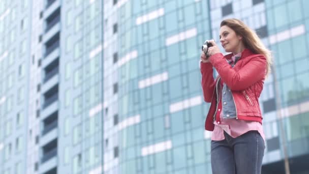 Atraente jovem turista tira fotos em uma câmera de filme — Vídeo de Stock
