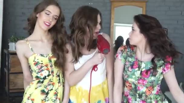 Vriendinnen hebben plezier en zingen in de droger in een microfoon. Drie aantrekkelijke meisjes gek rond en dans. Slow motion — Stockvideo