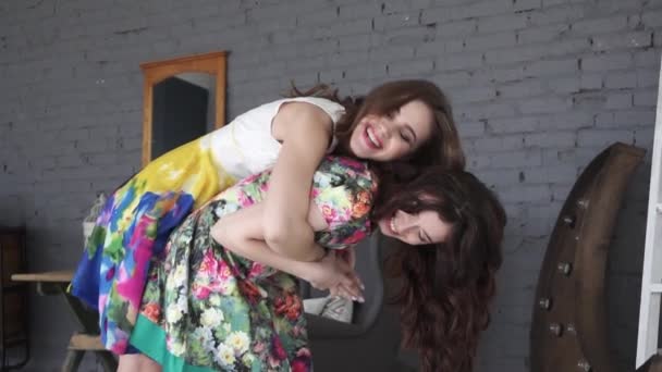 Zwei Freundinnen junge Freundinnen geben huckepack in den Urlaub lachend und lächelnd. Zeitlupe. — Stockvideo