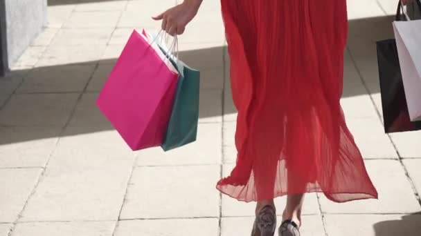 Σέξι πόδια από μια όμορφη κοπέλα που πηγαίνει με τσάντες αγορών. αργή κίνηση — Αρχείο Βίντεο