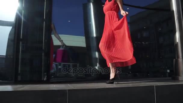 Pernas bonitas em sapatos com saltos ir ao longo da janela da loja de vidro. Pernas sexy close-up. bela menina em vestido vermelho com sacos de compras na mão apreciando o belo weather.SLOW MOTION — Vídeo de Stock