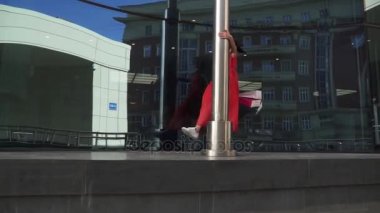 Neşeli kız çekici ve kaygısız paketleri satın almalarla elinde tutan şehir etrafında yürür. Ağır çekim