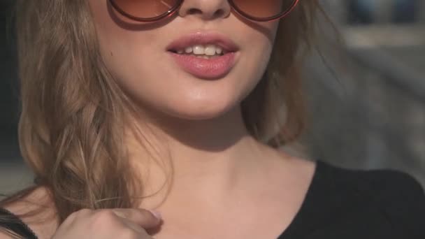 Close-up portret Urocza dziewczyna z sexy piękne usta. Blondynka w okulary pozowanie na kamery. zwolnionym tempie — Wideo stockowe