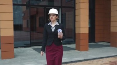 Elinde planları ile genç kadın mimar inşaat kask içinde. Kask oluşturucu. iş yerinde iş kadını